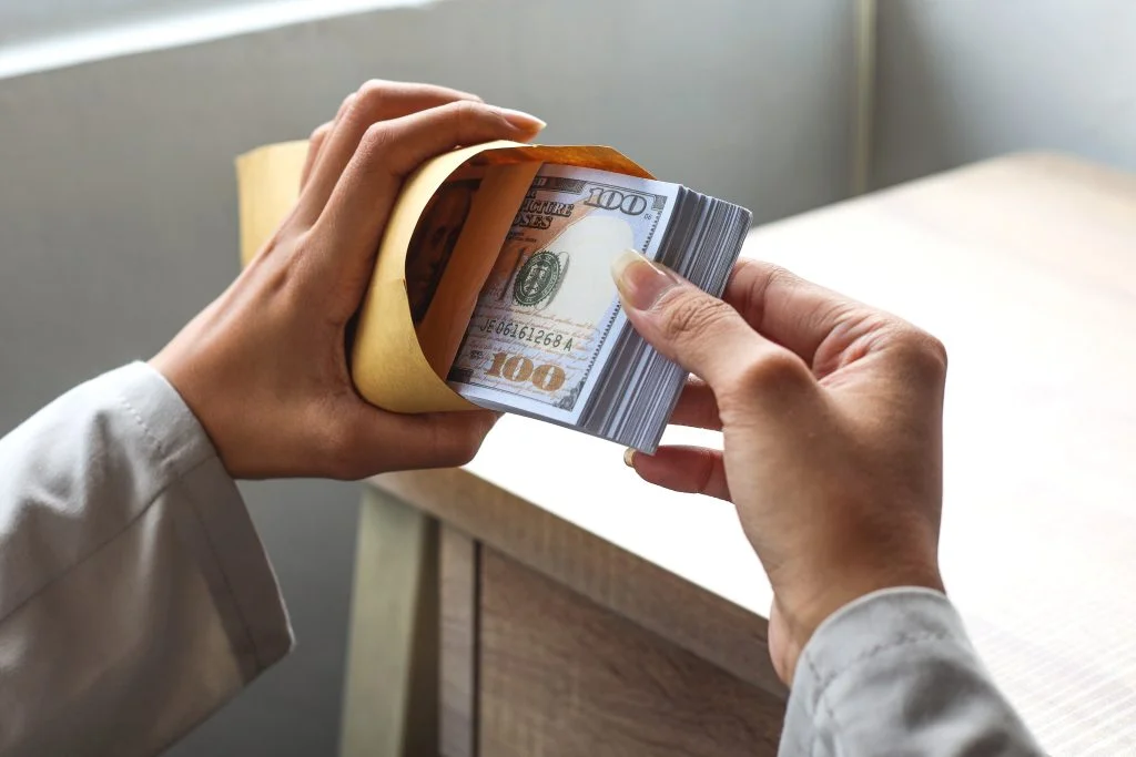 close-up-of-hands-take-hundreds-dollar-money-from-envelope