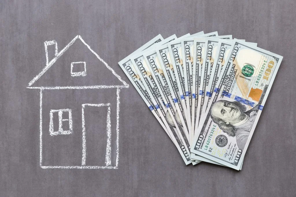 cash laying next to a drawing of a house