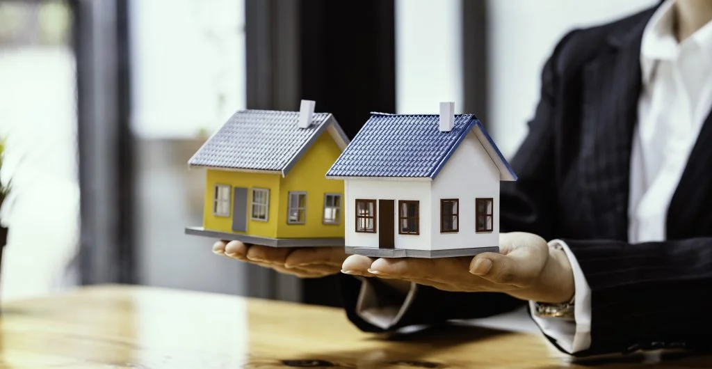 A real estate agent comparing two model homes.